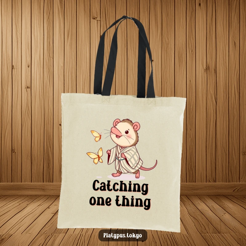 Funny tote bag with a charming platypus wearing a kimono, enthusiastically chasing a paper butterfly, ready for adventure.